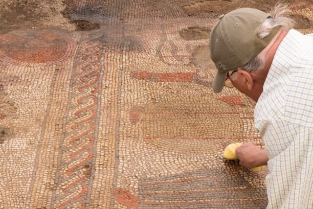 A member of the team from University of Leicester Archaeological Services during excavations of a large mosaic in Rutland, UK.