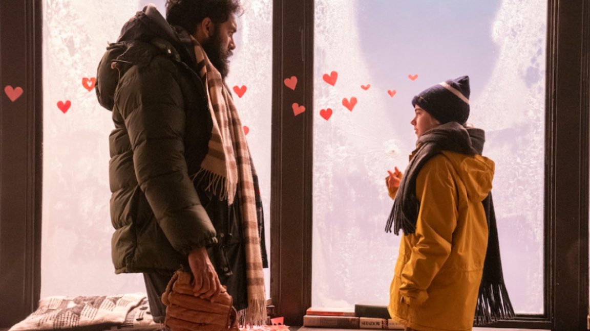 Man in parka facing young girl in winter gear