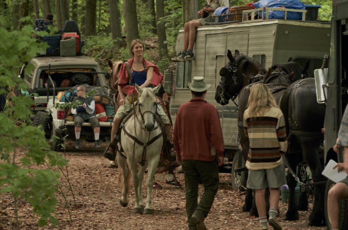Young woman on a horse with surrounding caravan