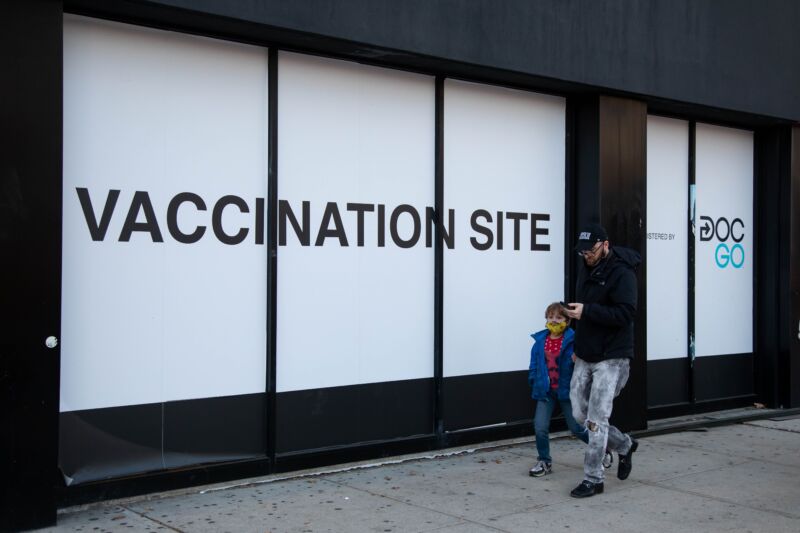 Pedestrians walk in front of a COVID-19 vaccination site in Brooklyn, New York, on Nov. 19, 2021. 