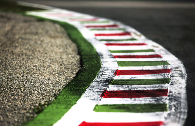 A painted curb at a race track, with a gravel trap immediately to its left