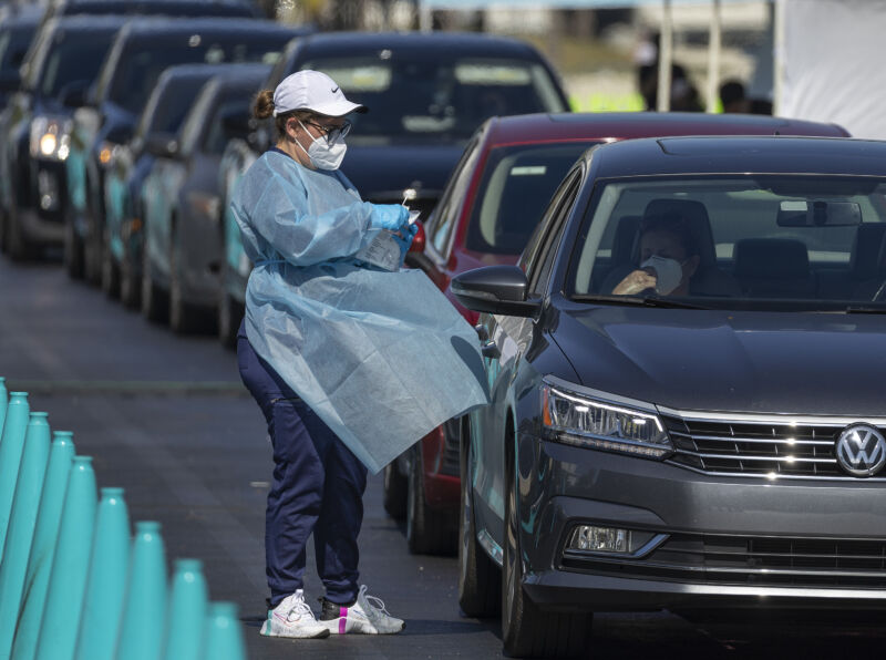 A healthcare worker conducts a test at a drive-thru COVID-19 testing site at the Dan Paul Plaza on December 29, 2021 in Miami, Florida. In response to the increasing demand for COVID-19 tests, Miami-Dade County opened two new testing sites and expanding hours at the Zoo Miami testing location.