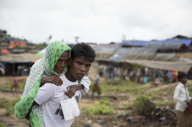 A woman clings to the back of a younger man.