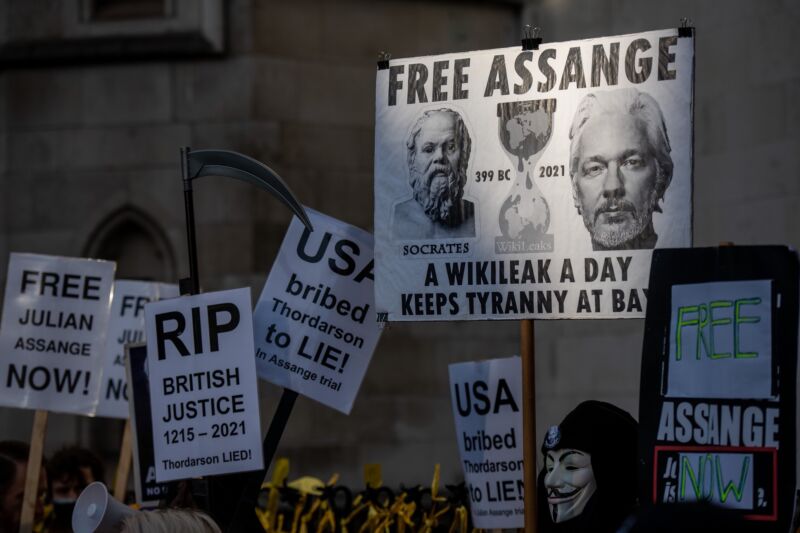 Protestors hold signs calling for Julian Assange to be freed.