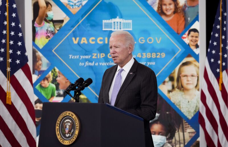 President Joe Biden speaks in front of a sign advertising the vaccines.gov Web site.