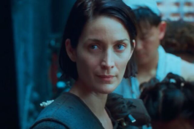 Carrie-Anne Moss returns as Trinity—or is she a suburban housewife named Tiffany?