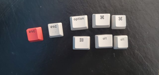 The keyboard comes with two Esc keycaps, plus caps for Mac (top right) and Windows (bottom right) layouts.