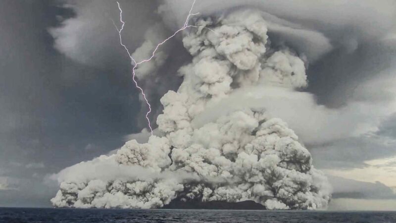 Smoke and lightning engulf and erupting volcano.
