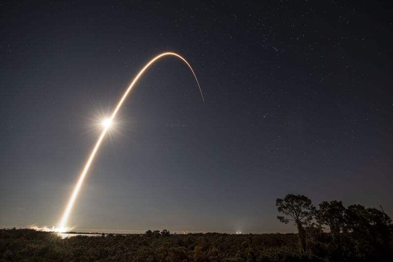 A rocket traces a bright arc across a dark sky.
