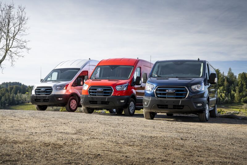 Three Ford transits of different roof heights parked next to each other. One is silver, one is red, one is blue.