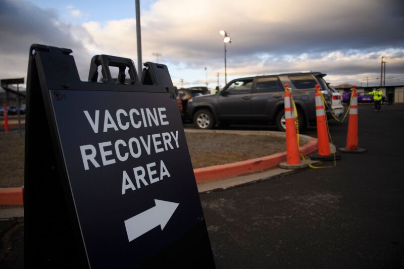Signage indicates a post-vaccination recovery area to monitor for any immediate side effects.