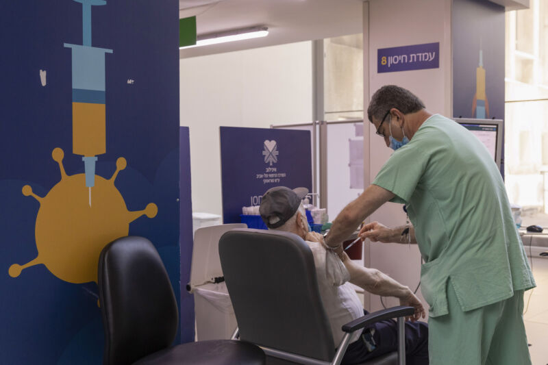 A health worker administers a third dose of the Pfizer-BioNTech COVID-19 vaccine to an elderly resident at Ichilov medical center in Tel Aviv, Israel, on Monday, Aug. 2, 2021. 