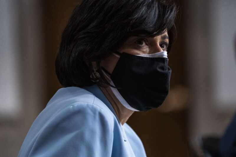A masked woman in a business suit.