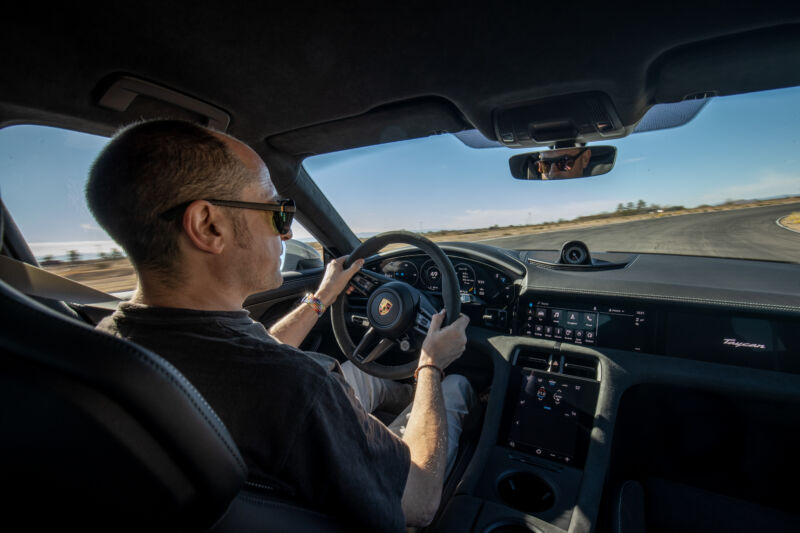 A person drives a Porsche Taycan on track