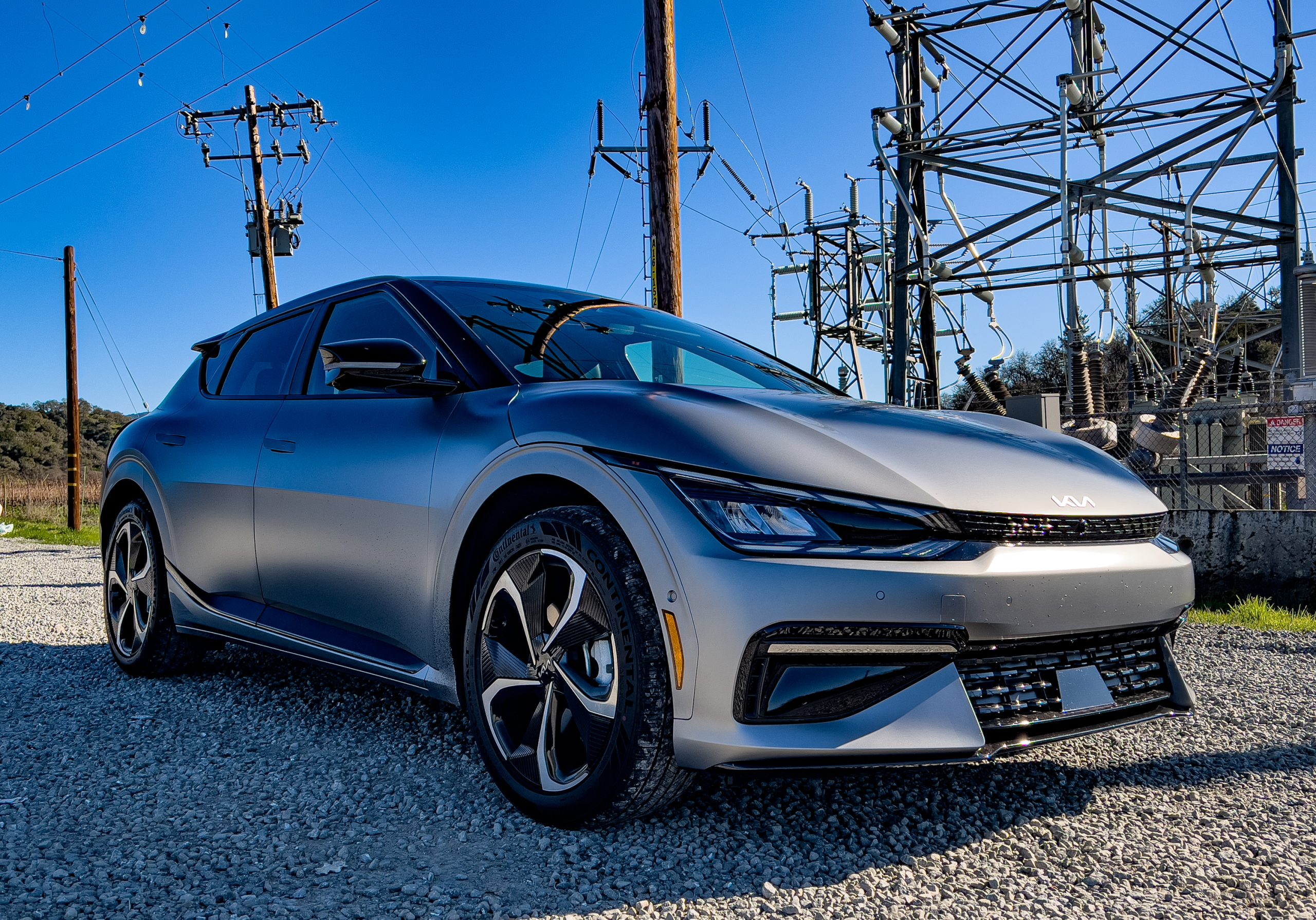 A Kia EV6 in front of an electricity substation