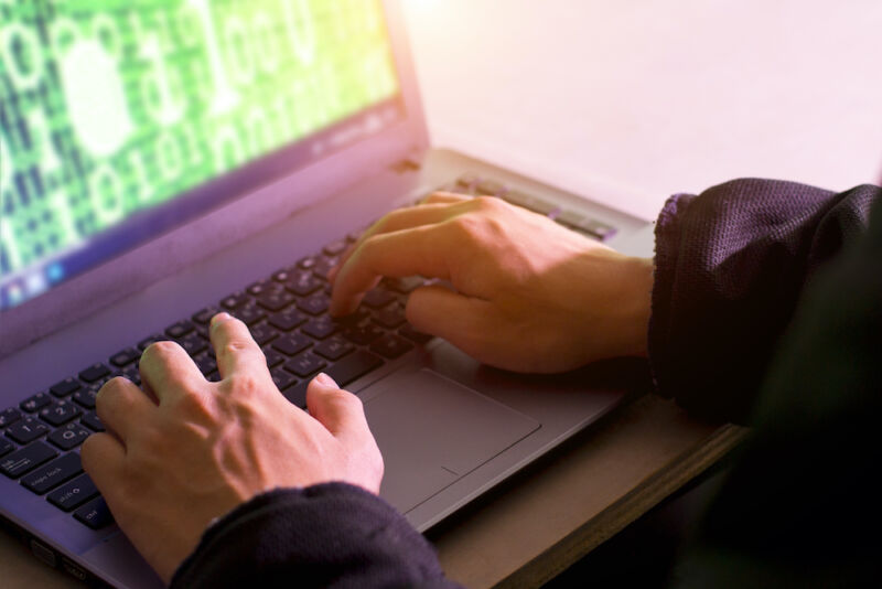 Un écran d'ordinateur portable rempli d'illustrations stylisées de la cybercriminalité.