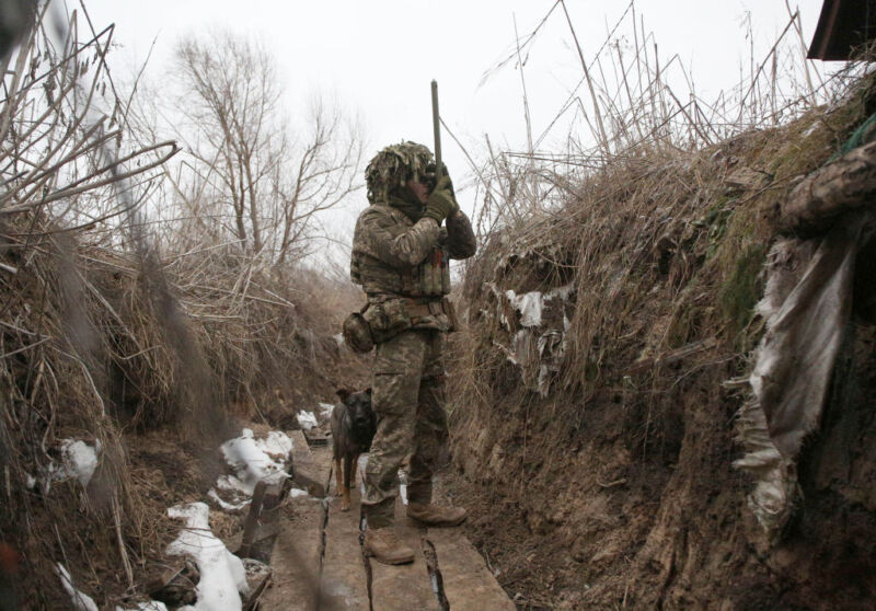 A Ukrainian Military Forces serviceman watches through a spyglass in a trench on the frontline with Russia-backed separatists near Avdiivka, southeastern Ukraine, on January 9, 2022.