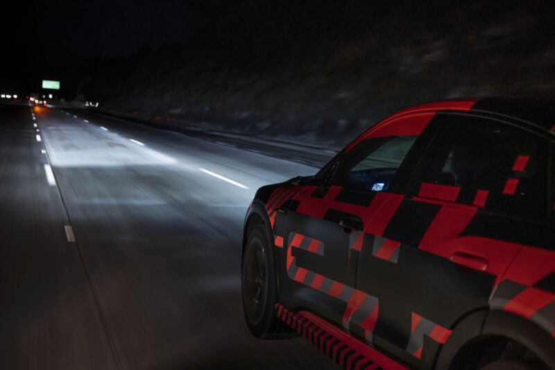 An Audi e-tron prototype on the highway in Europe lights its way ahead with adaptive beam headlights. 