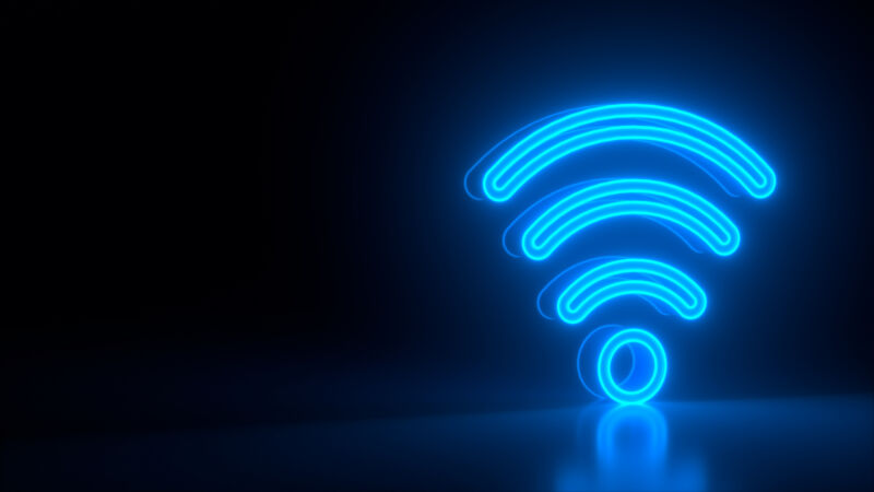 Futuristic glowing blue wi-fi symbol on black dark background with blurred reflection