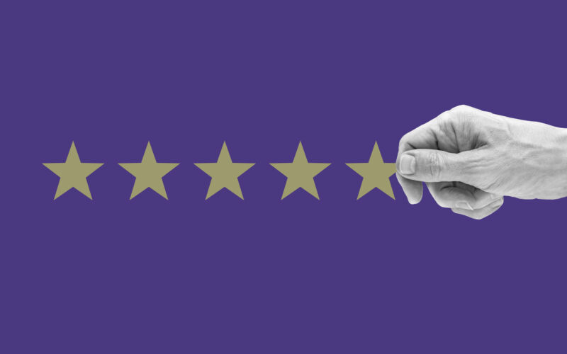 Cropped human hand arrange 5 stars against purple background.