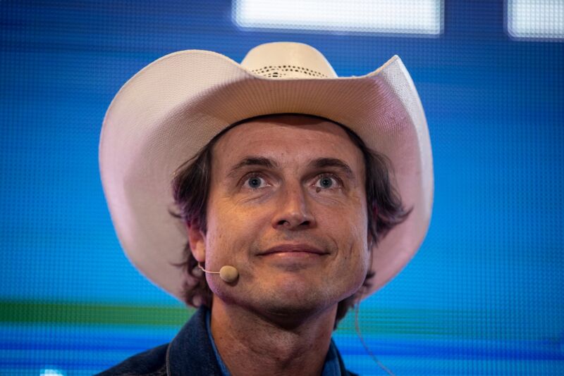 Kimbal Musk on stage at a conference, wearing a cowboy hat.