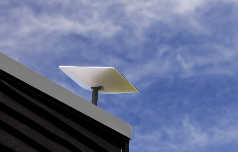 A rectangular antenna seen on a roof during daytime.