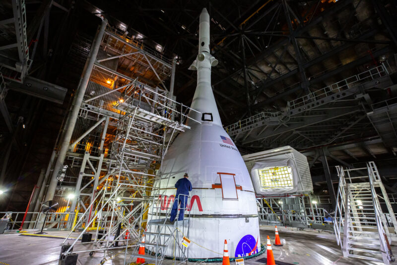 A technician works on the Orion spacecraft, atop the SLS rocket, in January 2022.