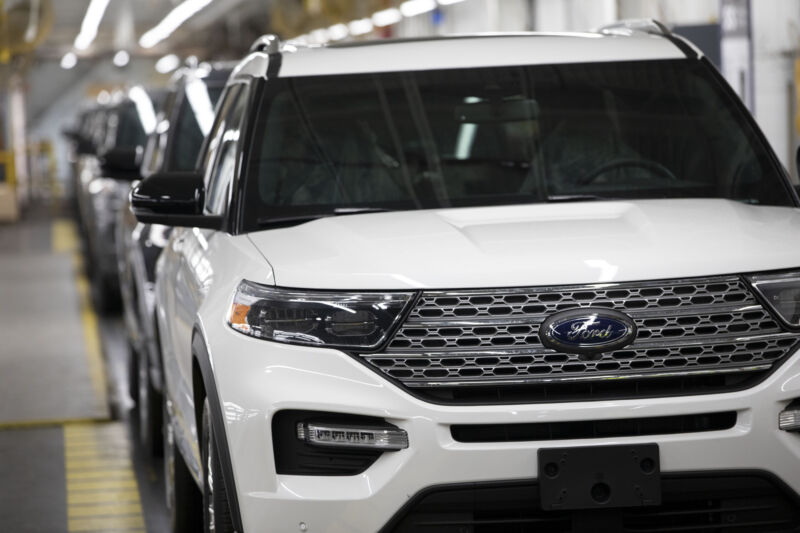 Cars on an assembly line.