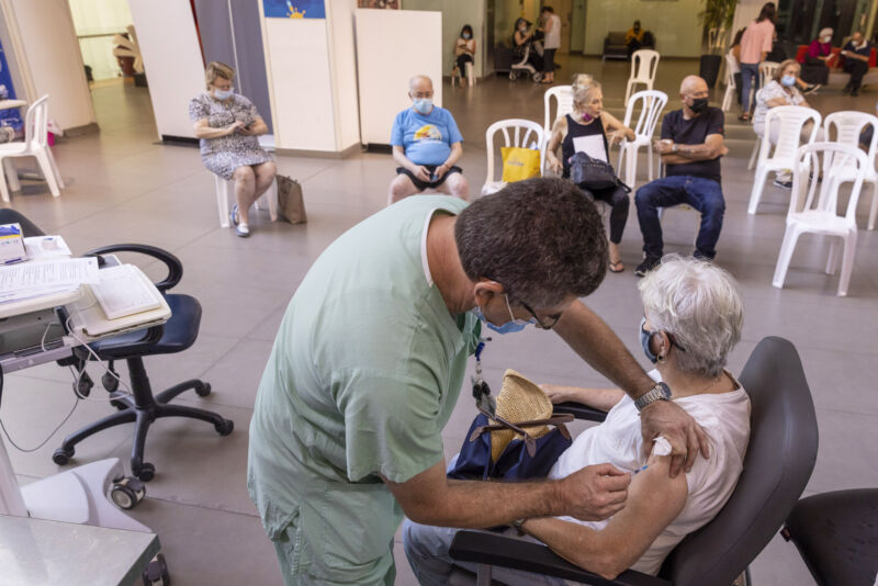 A health worker administers a third dose of the Pfizer-BioNTech COVID-19 vaccine to an elderly resident at Ichilov medical center in Tel Aviv, Israel, on Monday, Aug. 2, 2021.