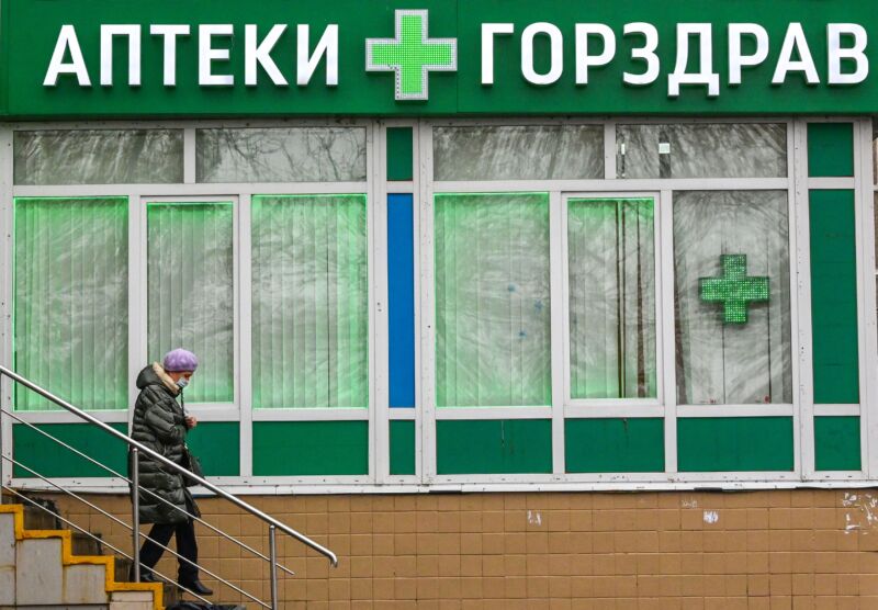 A woman wearing a face mask leaves a pharmacy in the town of Podolsk some 40 kilometers outside Moscow on November 12, 2021. 