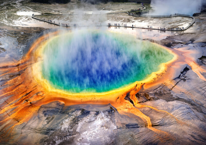 Image of a hot spring with intense colors in the water and surrounding soil.