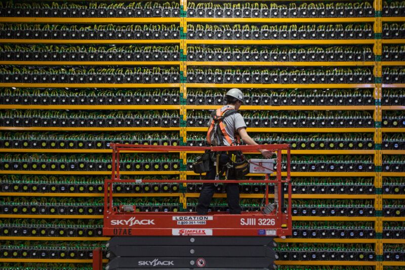 A technician inspects the backside of bitcoin mining at Bitfarms in Saint Hyacinthe, Quebec, on March 19, 2018.
