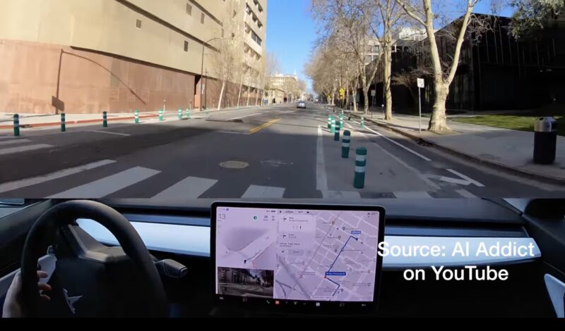 A view from inside a Tesla car a moment before it hit a bollard that appears to separate a car lane from a bike lane.