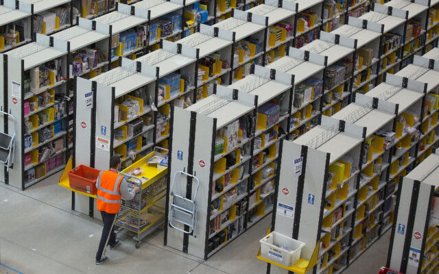 An employee processes customer orders ahead of shipping at one of Amazon.com Inc.'s fulfillment centers in Rugeley, UK.