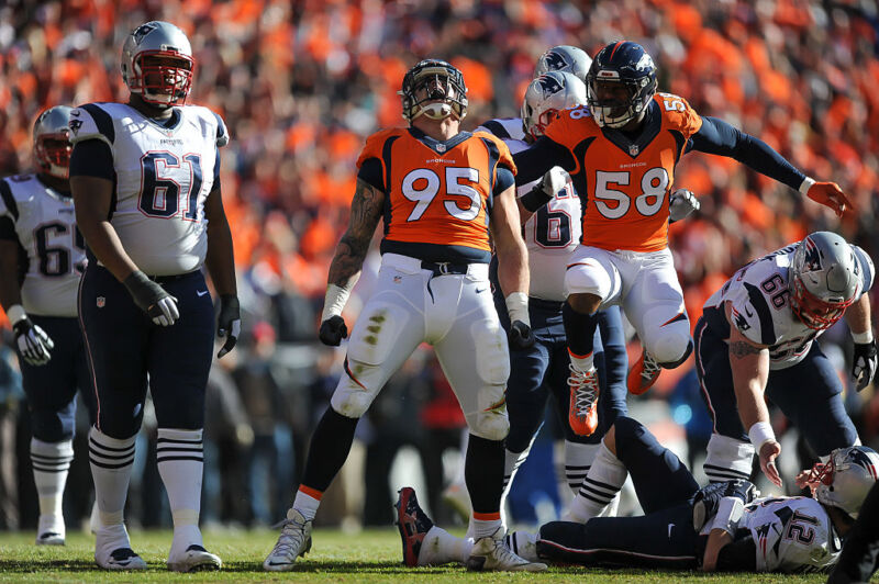 Derek Wolfe #95 and Von Miller #58 of the Denver Broncos celebrate after Wolfe sacked Tom Brady #12 of the New England Patriots  in the AFC Championship game at Sports Authority Field at Mile High on January 24, 2016 in Denver, Colorado.