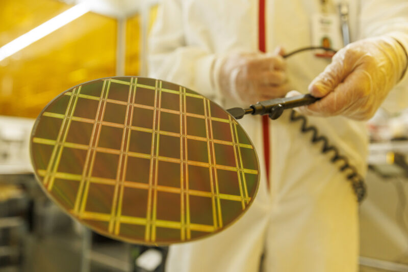 Technicians inspect a semiconductor wafer during testing in the cleanroom at the Tower Semiconductor Ltd. plant in Migdal HaEmek, Israel.