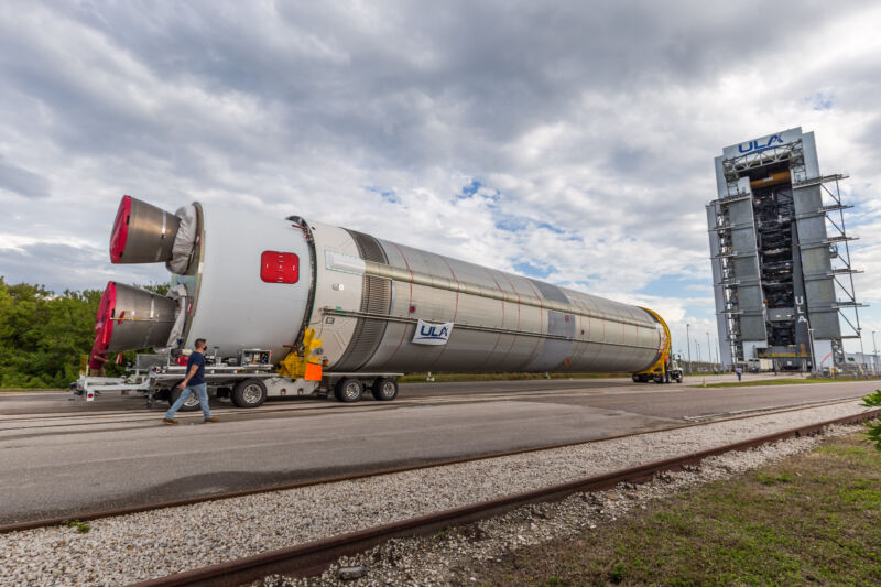 A giant rocket is transported on its side to a launch pad.