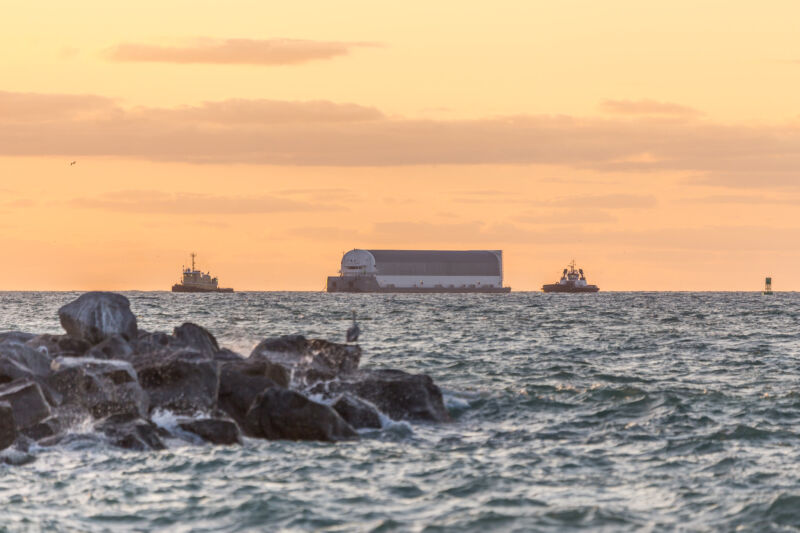 En United Launch Alliance Atlas V-booster bliver leveret til Cape Canaveral af NASAs <em>Pegasus</em>barge this week. “/><figcaption class=