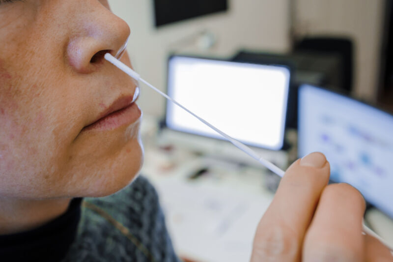 Una donna tiene un tampone nasale per un test rapido dell'antigene COVID-19 davanti al suo ufficio il 5 gennaio a Berlino.