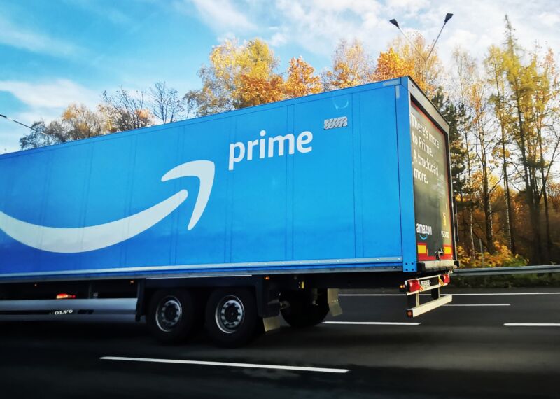 Un gran camión de reparto de Amazon Prime circula por una autopista.