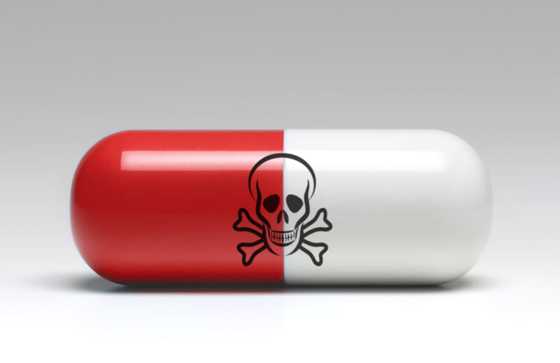 A pill with a skull and crossbones printed on it in an illustration of a poison pill.