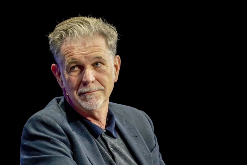 Netflix CEO Reed Hastings sitting on stage at a conference.