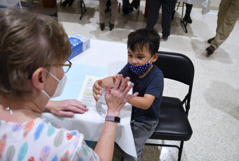 A boy gives a nurse a high five before receiving a shot of the Pfizer COVID-19 vaccine at a vaccination site for 5-11 year-olds at Eastmonte Park in Altamonte Springs, Florida.