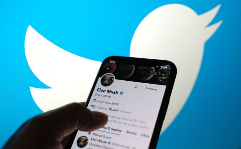 Esta foto ilustrativa tomada el 13 de mayo de 2022 muestra la cuenta de Twitter de Elon Musks con un logotipo de Twitter de fondo en Los Ángeles.  - Elon Musk envió mensajes contradictorios el viernes sobre su propuesta de adquisición de Twitter, presionando a las acciones de la plataforma de microblogging en medio del escepticismo sobre si el acuerdo se cerrará.  En un tuit de madrugada, Musk dijo que la adquisición de $44 mil millones fue "temporalmente en espera," preguntas pendientes sobre las estimaciones de la compañía de redes sociales sobre el número de  cuentas falsas o "robots"Eso hizo que las acciones de Twitter cayeran un 25 por ciento.  (Foto de Chris DELMAS / AFP) (Foto de CHRIS DELMAS/AFP a través de Getty Images)