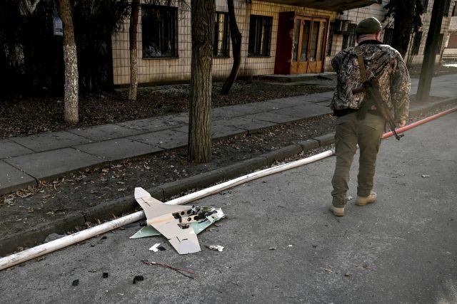 A Ukranian serviceman stands next to a downed Russian drone in the area of a research institute, part of Ukraine's National Academy of Science, after a strike, in northwestern Kyiv, on March 22, 2022.