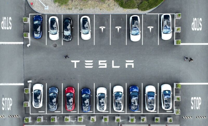 Aerial view of Tesla cars in a parking lot at the company's factor. The word