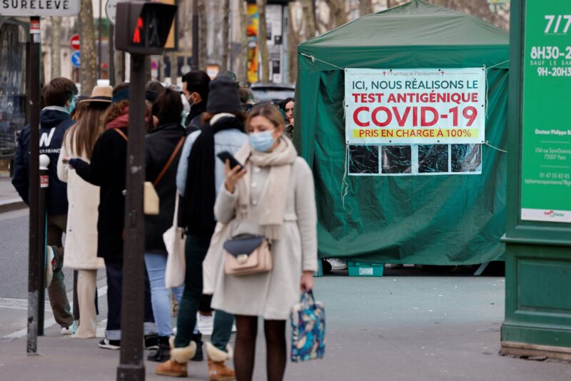 Members of the public queue outside a pharmacy to receive COVID-19 antigen tests in Paris on January 6, 2022.