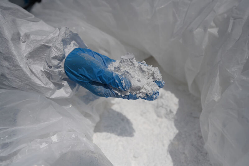 A customs officer inspects imported lithium carbonate at Longwu Branch Terminal of Shanghai İnternational Port Co., Ltd.