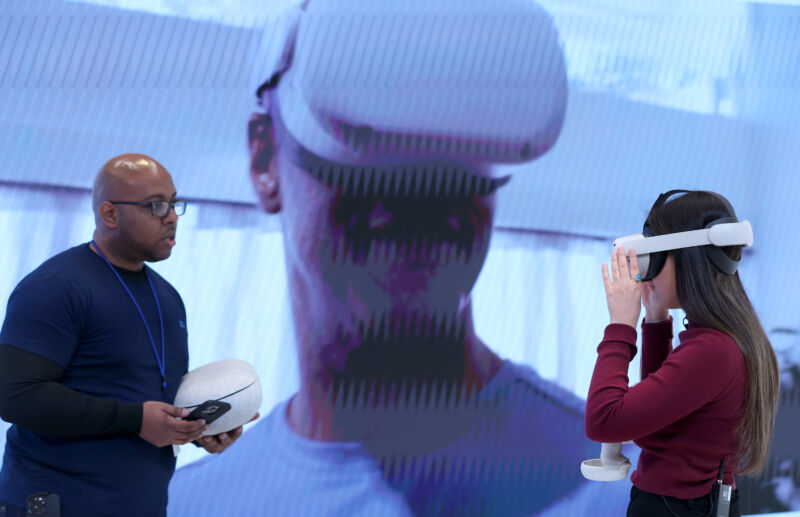 BURLINGAME, CALIFORNIA - MAY 04: Meta employee Ryan Carter (L) helps a member of the media with an Oculus virtual reality headset demonstration during a media preview of the new Meta Store on May 04, 2022 in Burlingame, California. Meta is set to open its first physical retail store on May 9. (Photo by Justin Sullivan/Getty Images)