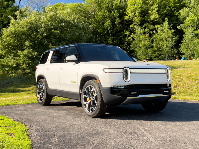 A white Rivian R1S in the late afternoon sun